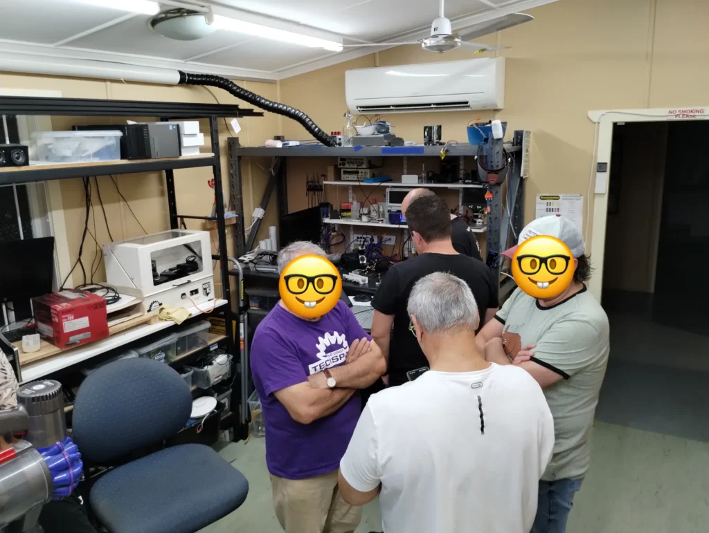 Members chatting around the workbenches in the Workshop