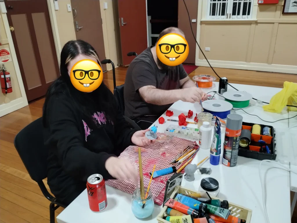Members painting models at a table during a meetup night in the Main Hall